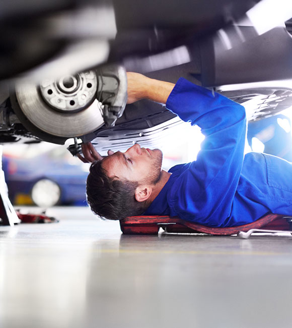 mechanic laying on his back working under car