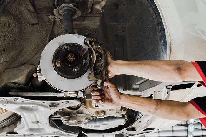 closeup of mechanic replacing disc brakes