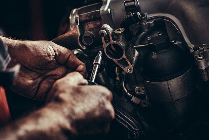 close-up of a man's hands working on a diesel engine